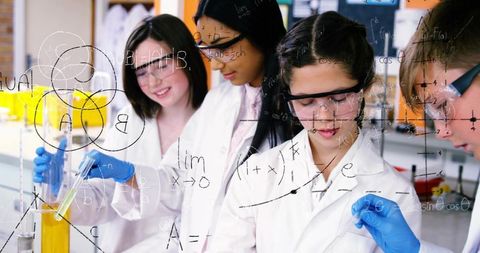 Students conducting chemistry experiment with pipettes, test tubes and beakers in school laboratory