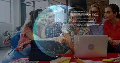 Creative team collaborating on laptop with holographic globe and code overlay for global innovation