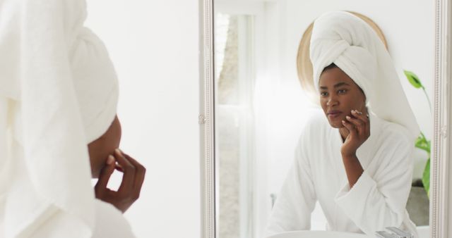 Woman in Bathrobe and Towel Looking into Mirror in Comfortable Bathroom - Download Free Stock Images Pikwizard.com