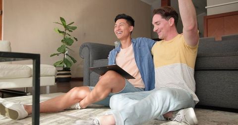 Diverse Male Couple Sharing Tablet at Home