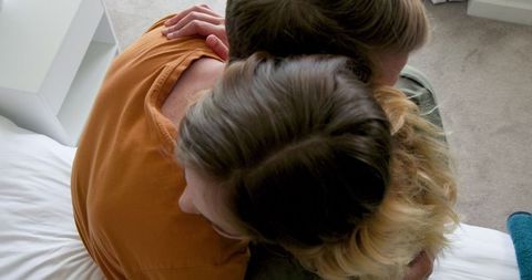 Couple embracing and smiling at home in anticipation of new baby