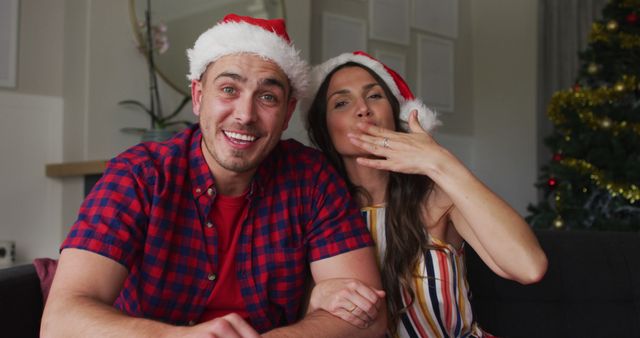 Festive Couple Celebrating Christmas at Home with Santa Hats - Download Free Stock Images Pikwizard.com