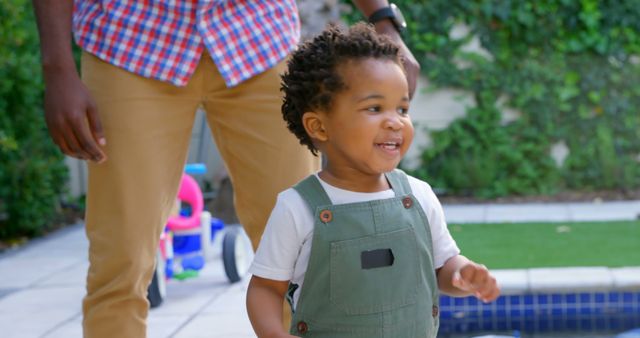 Smiling Toddler Playing Outdoors Near Pool with Adult Supervising - Download Free Stock Images Pikwizard.com