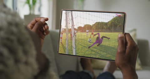 Man Watching Soccer Game on Tablet at Home