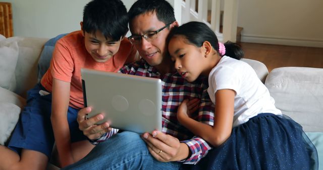 Father Enjoying Quality Time with Children Watching Tablet on Couch - Download Free Stock Images Pikwizard.com