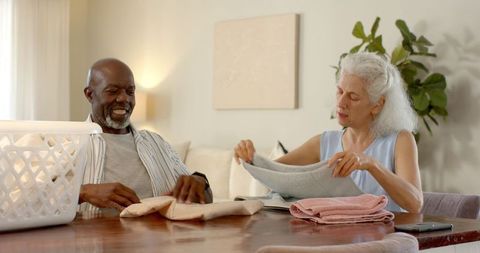Senior couple folding laundry with harmony in contemporary home