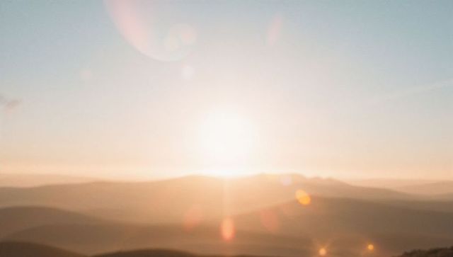 Scenic sunrise illuminating misty rolling hills