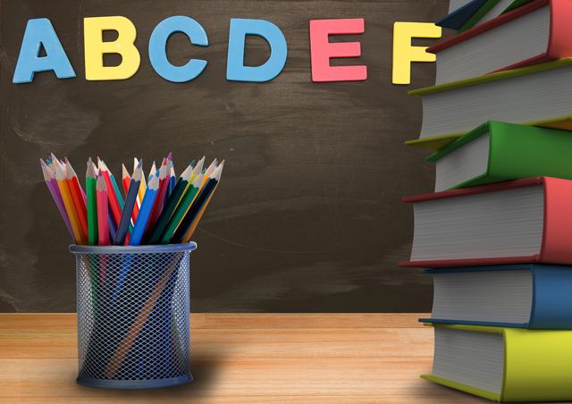 This image features a classroom scene with a pen holder filled with colorful pencils and a stack of books on a wooden desk. The background includes a blackboard with alphabet letters in vibrant colors. Ideal for educational materials, school promotions, and learning resources.