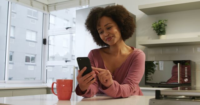 Young Biracial Woman Relaxing at Home Checking Phone in Bright Modern Kitchen - Download Free Stock Images Pikwizard.com