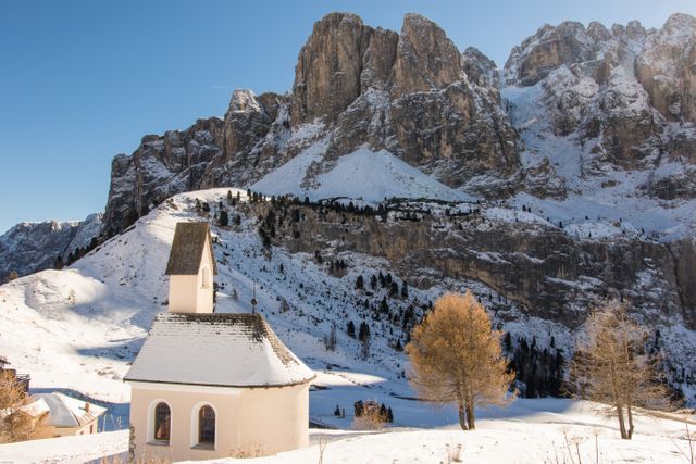 This snowy church scene amongst mountains creates a serene and peaceful atmosphere. Ideal for use in winter tourism promotions, travel blogs, nature calendars, and religious publications. Perfect to convey tranquility, beauty, and the majestic appeal of alpine landscapes.