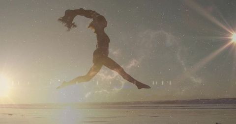 Silhouette of Woman Bounding Over Beach at Sunrise