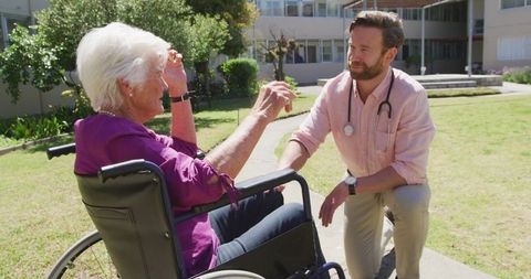 Doctor Interacting with Senior in Wheelchair at Retirement Home Outdoors