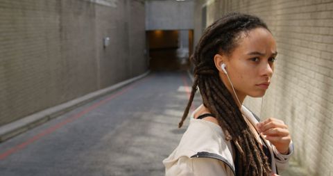Young African American Woman Listening to Music in City
