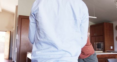 Friends Embracing Cheerfully in Modern Kitchen