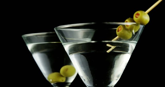 Close-up of martini glasses with olives on black background - Download Free Stock Images Pikwizard.com