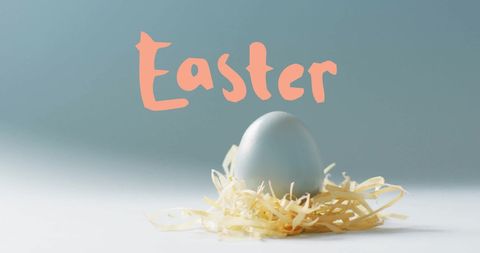Pastel easter egg on straw with festive text