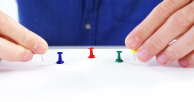 Person Arranging Colorful Push Pins on White Desk - Download Free Stock Images Pikwizard.com