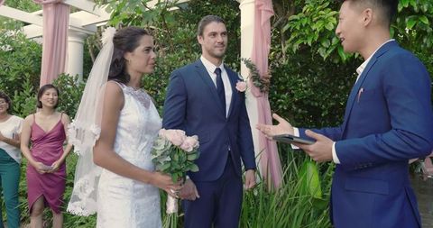 Bride and Groom Exchanging Vows Outdoors Amidst Greenery