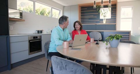 Senior Couple Using Laptop in Modern Kitchen