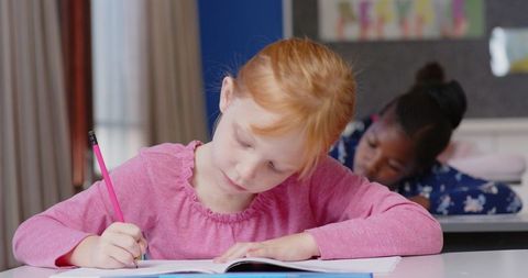 Diligent Elementary School Student Writing with Focus and Concentration
