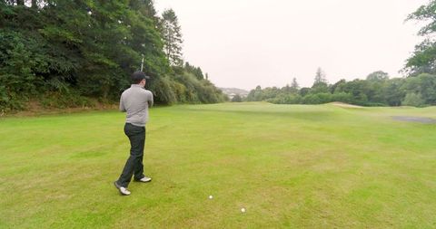 Golfer on fairway preparing shot with precision on lush green course