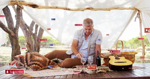 Serene outdoor picnic with guitar and wine under canopy