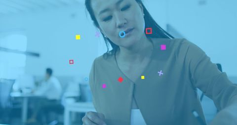 Asian businesswoman engaging with digital network interface in office