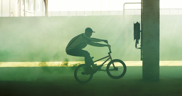 Young Caucasian man rides a BMX bike in a misty urban setting - Download Free Stock Photos Pikwizard.com