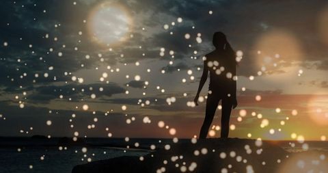 Silhouette Dancing Amidst Bokeh Lights at Vibrant Sunset