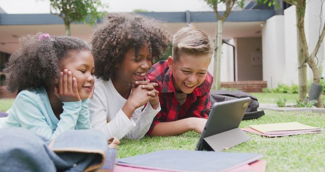 Happy Children Laying on Grass Watching Tablet Outside - Download Free Stock Images Pikwizard.com