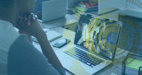Senior woman working on laptop with holographic interface during virtual meeting in office