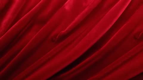 Slow-moving red velvet curtain revealing deep diagonal folds and plush velvety texture