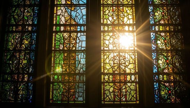 Sunlight streaming through colorful stained glass window