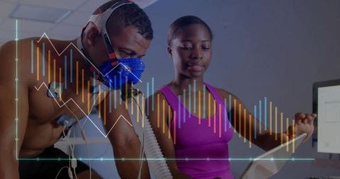 Athlete undergoing cardiopulmonary test while coach monitoring exercise performance data