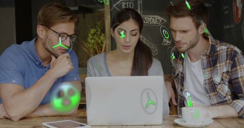 Coworkers collaborating over laptop with augmented reality holograms and coffee