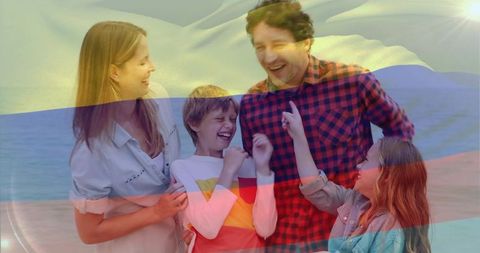 Laughing family enjoying beach with flag overlay and sun flare