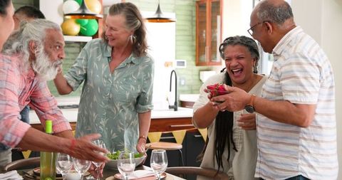 Diverse seniors enjoying festive dinner preparations at home