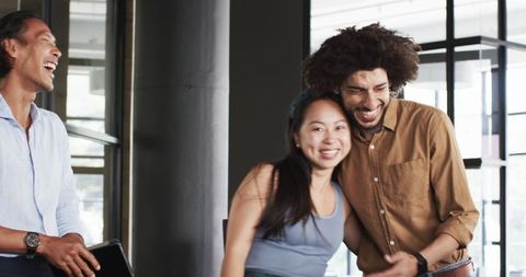 Diverse Colleagues Sharing a Joyful Work Moment in Modern Office