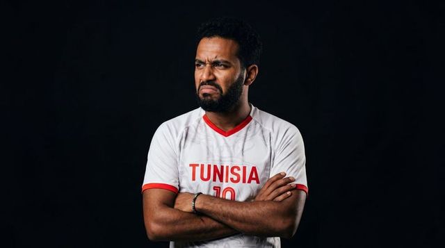 Scowling tunisian football fan crossing arms wearing no 10 jersey