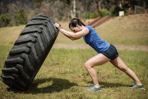 Female athlete tire flipping in outdoor fitness training