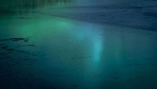 Glowing Turquoise Water Reflecting Twilight Light over Glassy Lake Surface