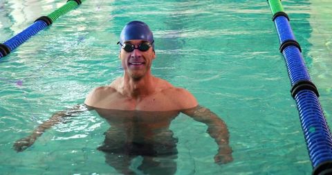 Competitive Swimmer in Turquoise Pool Area Ready to Start