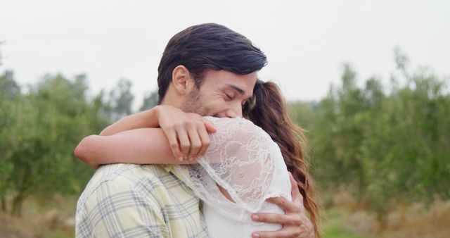 A young couple shares a loving embrace outdoors, symbolizing their affection and intimacy. - Download Free Stock Photos Pikwizard.com