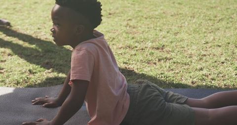 Young Boy Practicing Yoga Outdoors in Sunlit Park