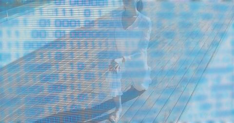 Solitary woman sitting on wooden deck wearing dress with blue binary data overlay