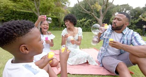 Family Enjoying Bubble Blowing in Garden on Sunny Day - Download Free Stock Images Pikwizard.com