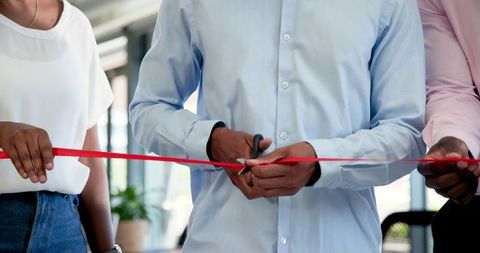 Business team cutting ribbon for new office opening