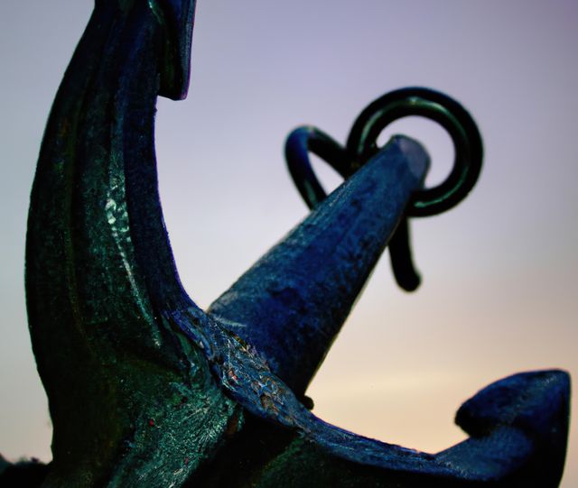 Image depicts a closeup of a weathered ship anchor against a colorful sky, possibly during sunset. Great for maritime, nautical-themed projects, boating and shiprelated applications, or creating vintage-style designs. Suitable as a background for marine industry promotions, travel brochures, and educational materials about marine navigation.