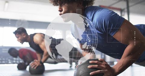 Diverse Group Working Out Intense Push-ups on Medicine Balls