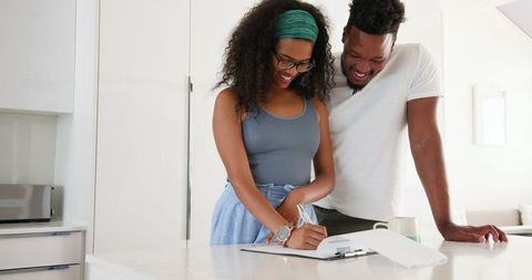 Happy coupled planning domestic future together in modern kitchen